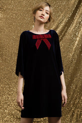Velvet shift dress with oversized bow detail and relaxed mid-thigh silhouette for evening elegance